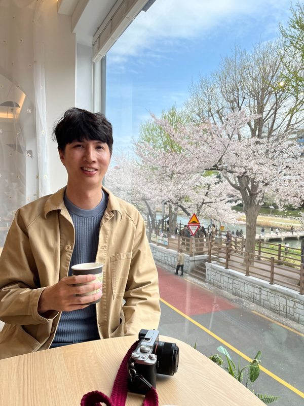 Chris Norlund at a café in Korea with cherry blossoms